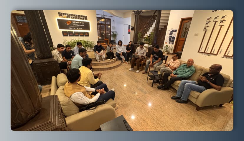 The Shifu office mid-session, a room of founders seated around the lounge under the ARR board.